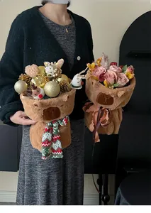 Detail of Christmas plush bear buckets with golden ornaments and fresh pink roses