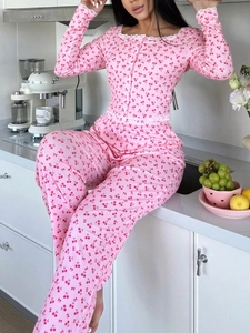 Détail d'un pyjama rose à motif cerises avec bordure en dentelle blanche délicate