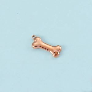 Detailed view of rose gold dog bone charm with amber zircon and metal ring