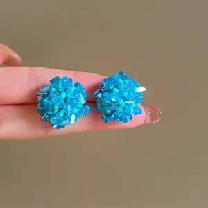 Vue détaillée de boucles d'oreilles en perles bleues avec textures de cristal facetté