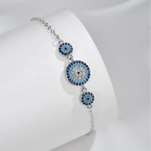 Silver S925 Evil Eye bracelet with blue zircon crystals on a white display stand