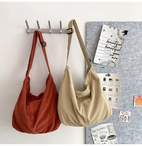 Corduroy tote bags in caramel and beige hanging on a wall showing large capacity design