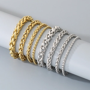 Detail view of gold and silver stainless steel basket-weave chains on a display stand