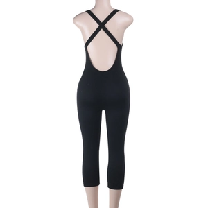 Detail of cross-back straps on black tight athletic jumpsuit with open back design