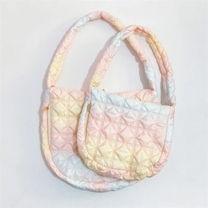 Close-up of pink gradient cloud bags with quilted texture and golden zippers