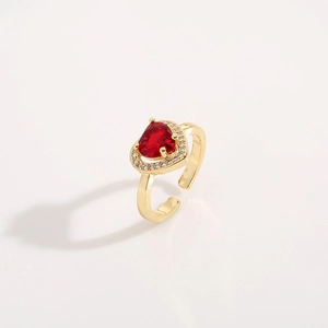 Gold plated open ring with red heart gemstone and white pavé crystals on white background
