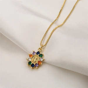 Detail showing gold Virgin Mary pendant with colorful zircons on white silk fabric