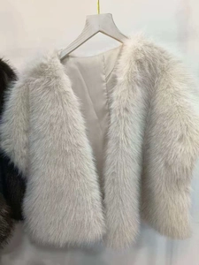 Detailed view of beige faux mink fur vest on a wooden hanger with soft plush texture