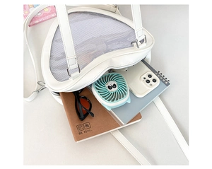 Detail view of heart-shaped white Ita Bag showing capacity for B5 notebook and phone