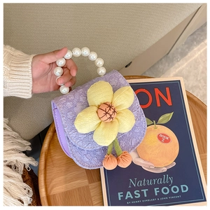 Detail of purple pleated kids handbag with yellow flower and pearl handle