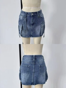 Detail of blue denim utility skirt featuring large cargo pockets and washed finish