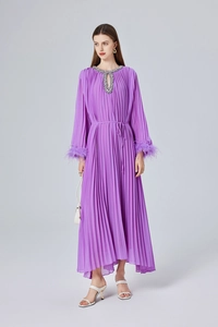 Détail de robe plissée violette avec poignets en fourrure et col orné de strass