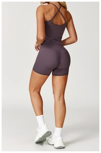 Dettaglio delle spalline incrociate sul retro e shorts a vita alta nel set sportivo viola