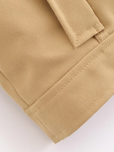 Gros plan sur la texture en coton sergé kaki et les coutures précises de la veste décontractée