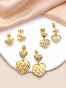 Detailed macro view of gold heart earrings set featuring zircon pavé and textured patterns
