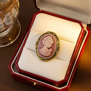Vintage Victorian style cameo brooch with golden leaf frame in a red jewelry box