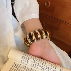 Detail of vintage stretch bracelet featuring amber resin and golden metal twisted links