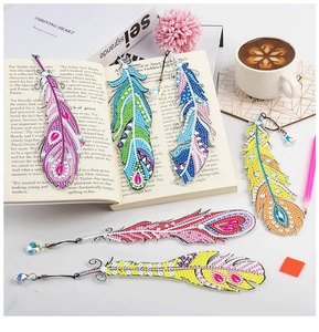 DIY diamond painting feather bookmarks with crystal pendants and tool kit on a book