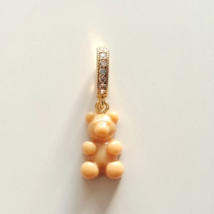 Detail of cream gummy bear pendant with gold rhinestone clasp on resin necklace