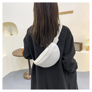 Rear view of a model wearing a white crescent-shaped leather chest bag over a black coat