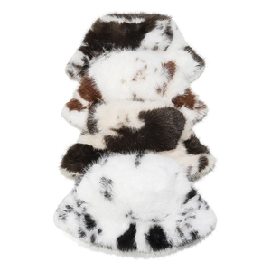 Detailed close-up of faux fur bucket hats featuring black and white cow print textures