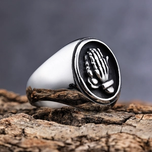 Men's stainless steel signet ring with embossed praying hands on black background