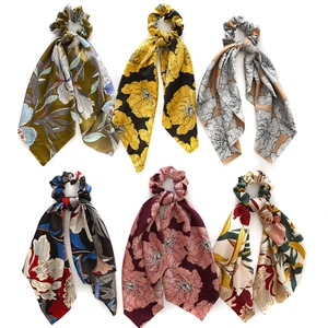 Detail of assorted floral satin scrunchies with long ribbons in multiple elegant colors