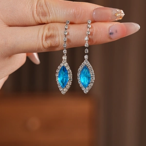 Close-up of elegant blue marquise crystal drop earrings with sparkling silver chains