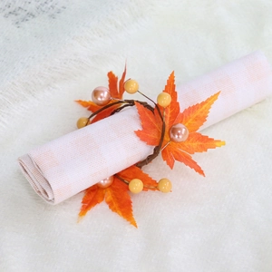 Detail of harvest maple leaf napkin ring with berries on a checkered cloth napkin