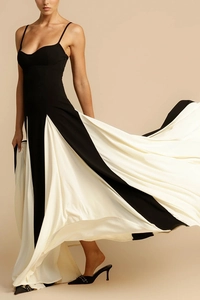 Dynamic detail of black and white color-block maxi dress with pleated skirt and thin straps