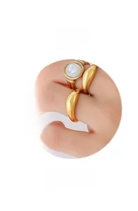 Detail of a minimalist gold ring set featuring a white round stone and wavy band