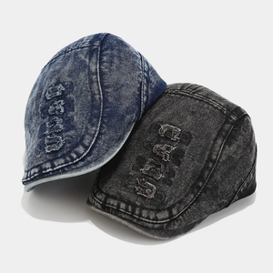 Detailed macro of vintage washed denim newsboy caps with distressed hole accents