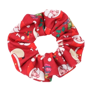Detail of red Christmas scrunchie with festive Santa Claus and gift box patterns