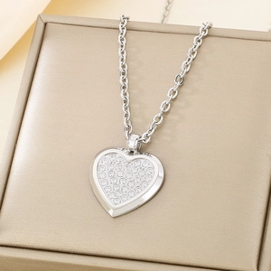 Detailed macro of a sparkling crystal heart pendant necklace resting on a gold jewelry box