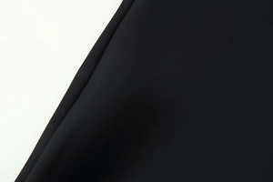 Dettaglio del tessuto nero di alta qualità con cuciture precise e finiture impeccabili