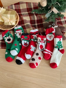 Flat lay of colorful coral fleece Christmas socks with festive reindeer and tree patterns