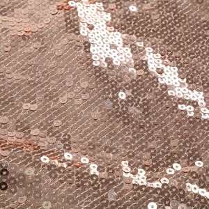 Macro view of high-density rose gold sequins on a two-piece skirt set fabric