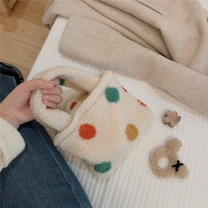 Detailed view of plush lamb wool handbag with colorful polka dots and soft texture
