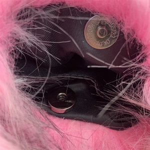 Detailed close-up of pink faux fur bag featuring black lining and a magnetic metal clasp