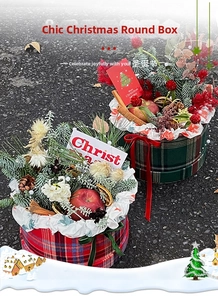 Plaid Christmas gift boxes with artificial pine branches, red apples, and pinecones