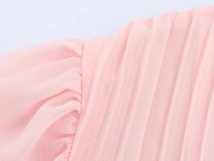 Macro shot of pink pleated chiffon fabric texture showing fine vertical fold details
