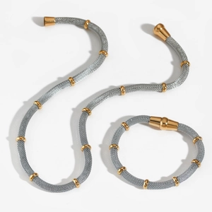 Silver mesh chain jewelry set with gold bamboo rings and magnetic clasp on white backdrop