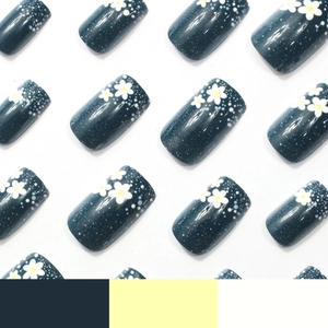 Navy blue press-on nails featuring white floral patterns and starry polka dot designs