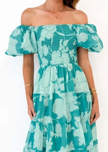 Détail de l'encolure à épaules dénudées et du bustier smocké de la robe fleurie verte