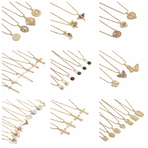 Golden fashion necklace collection with wolf tooth, heart and cross pendants