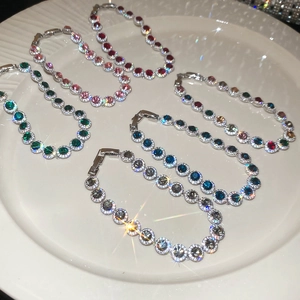 Détails de six bracelets tennis en zircone colorée présentés sur une assiette en céramique