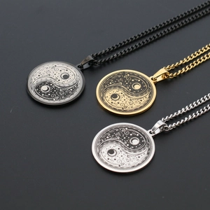 Detailed view of Yin Yang pendants with sun and moon patterns in black, gold, and silver