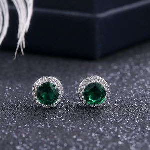 Detail showing halo stud earrings with green round gemstone and clear zircon border
