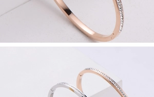 Close-up of rose gold and silver geometric bracelets with sparkling zircon inlay