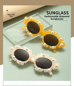 Detail of polarized sunglasses featuring floral frames and embedded white pearls